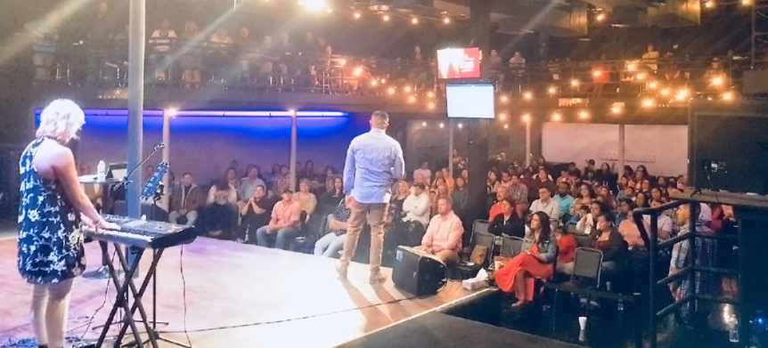 A man standing on the runway in front of an audience.
