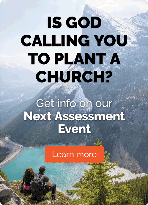 A church with mountains in the background and an orange sign