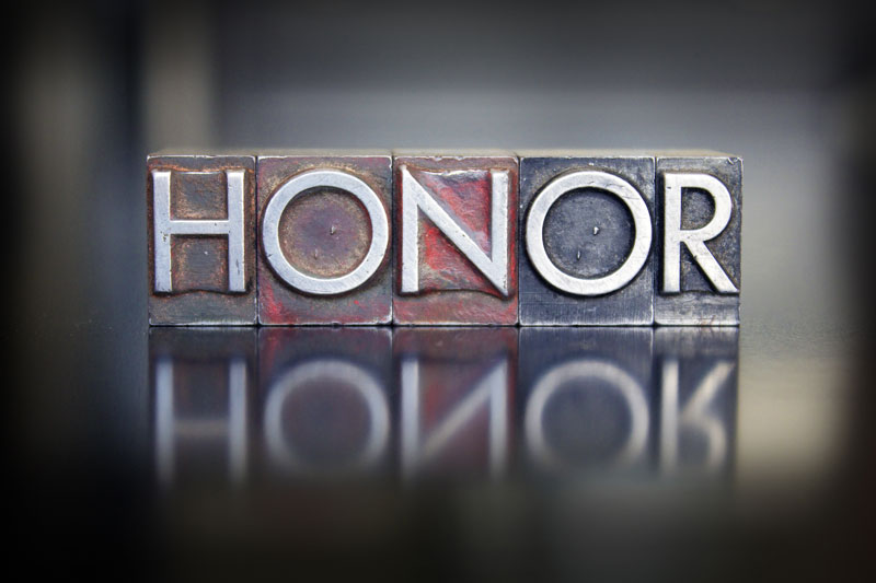 A close up of the word honor in old metal type